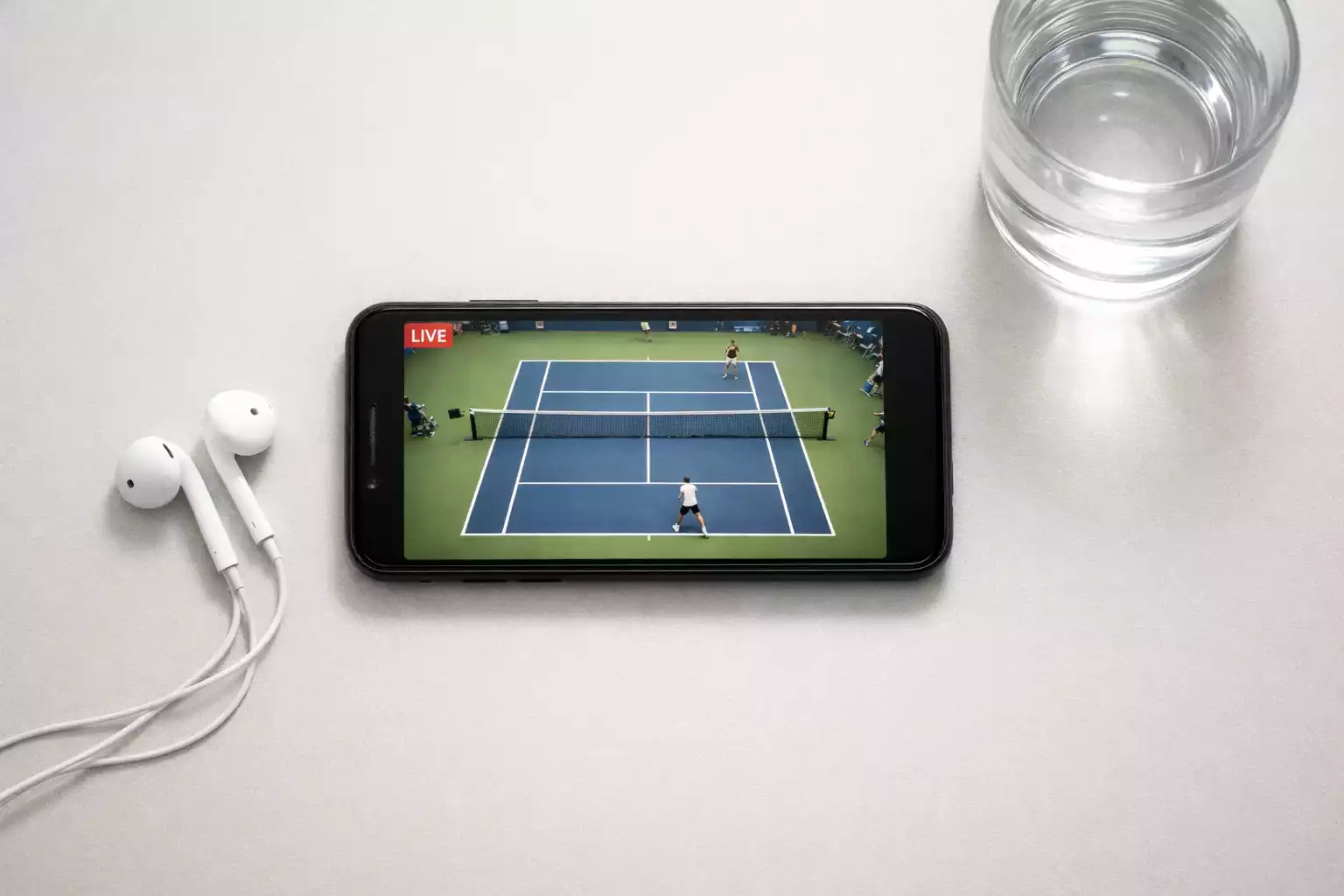 Tennis-Livestream auf einem Smartphone mit Kopfhörern daneben