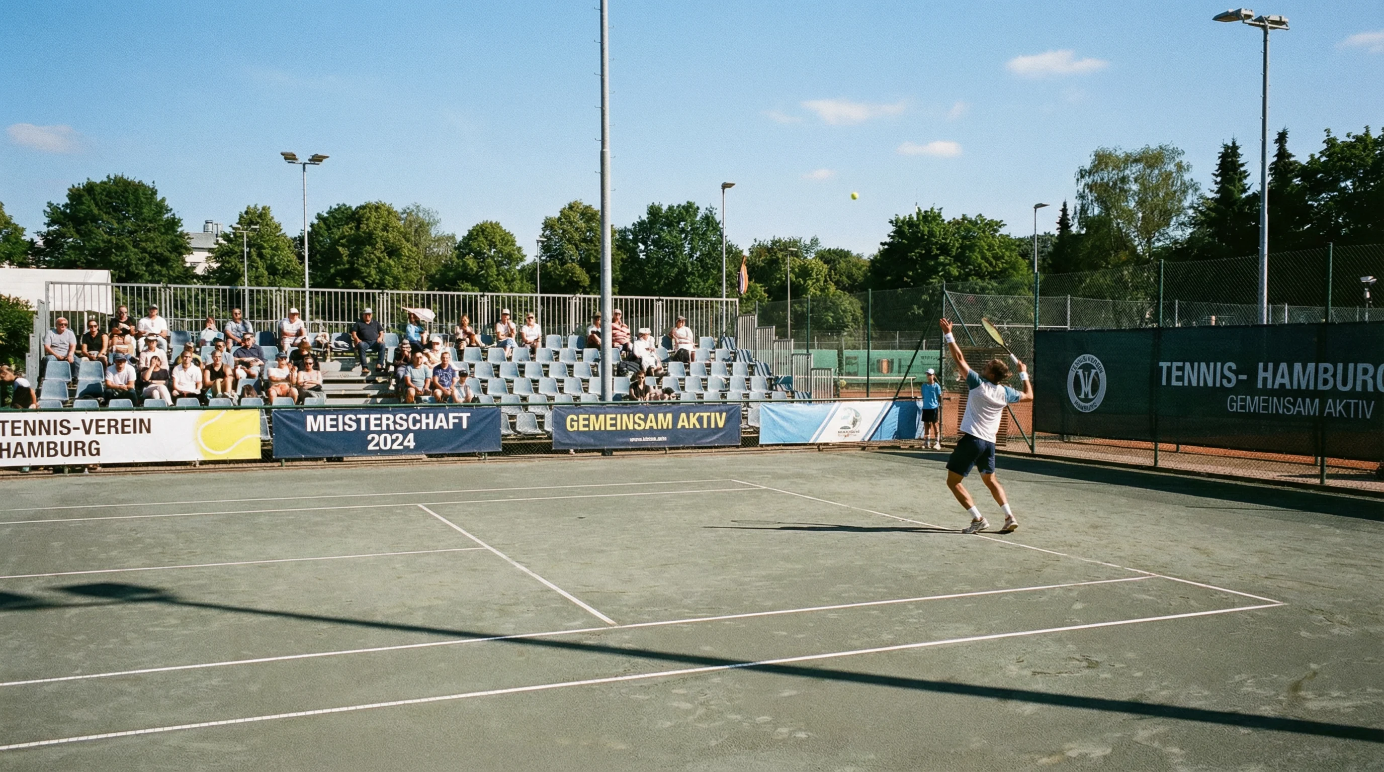 Kleines Tennisturnier mit wenigen Zuschauern auf einem Außenplatz